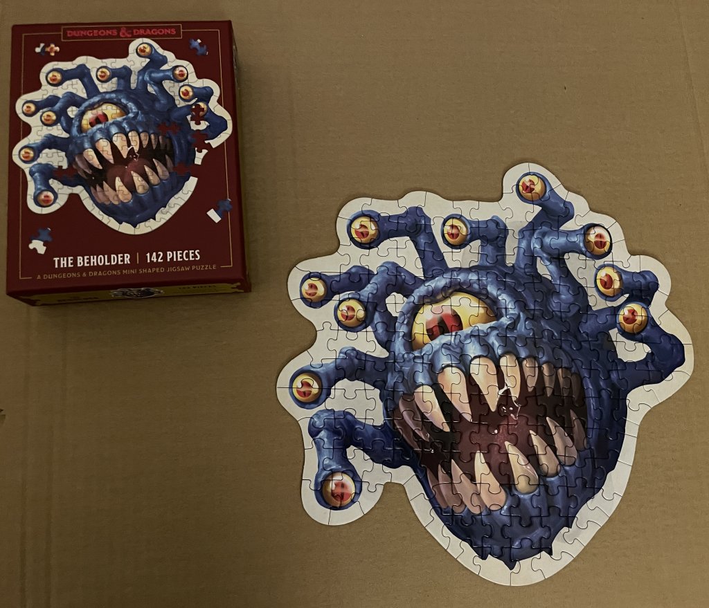Photo of the assembled Beholder puzzle and the box